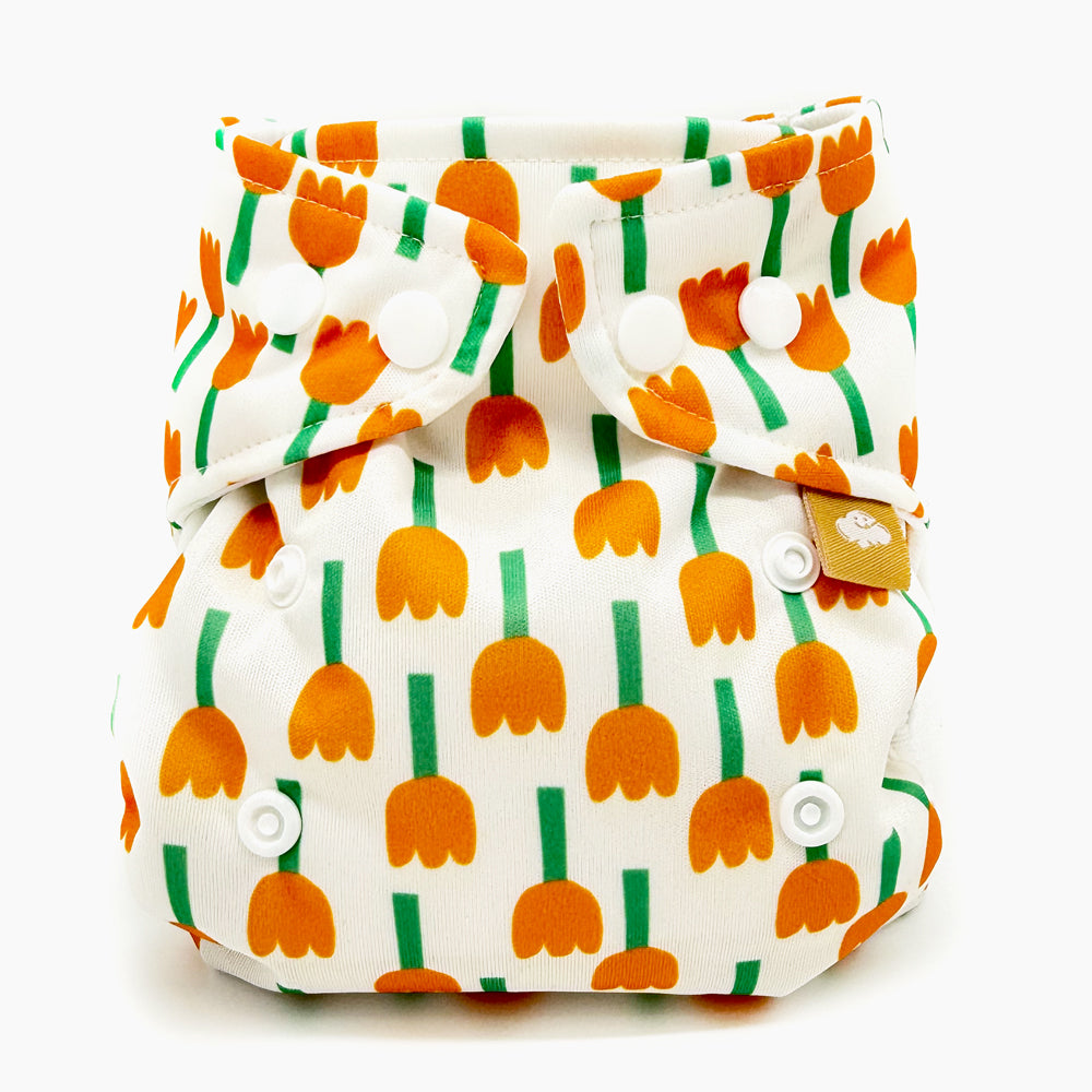 Little Clouds Prefold-Überhose Gold Edition im Design Tulpen schräg von vorn: orange Tulpen auf weißem Grund
