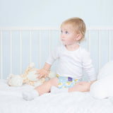 Baby sitzt im Bett in Bambino Mio MioSolo Dreamy Giraffe
