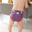 Kind trägt die Culla di Teby „Soft Touch“ Überhose und Schwimmwindel im Design Blumenwiese