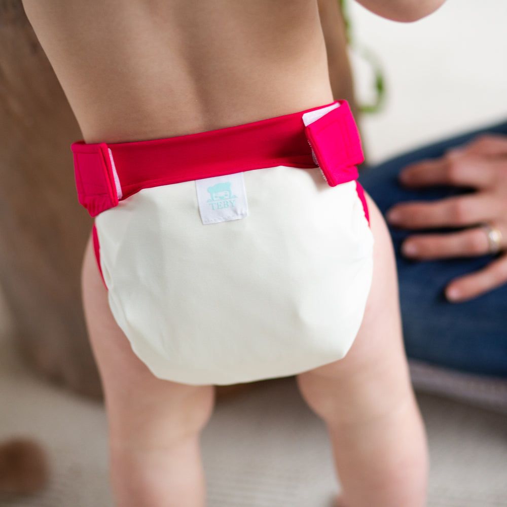 Kind trägt die Culla di Teby „Soft Touch“ Überhose und Schwimmwindel im Design Creme & Pink