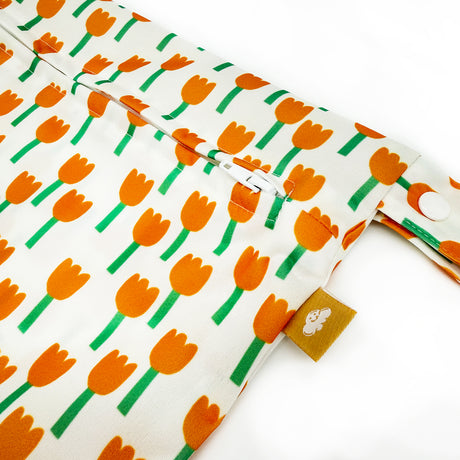 Nahaufnahme des Stoffdrucks der Little Clouds Nasstasche Gold Edition im Design Tulpen: orange Tulpen auf weißem Grund