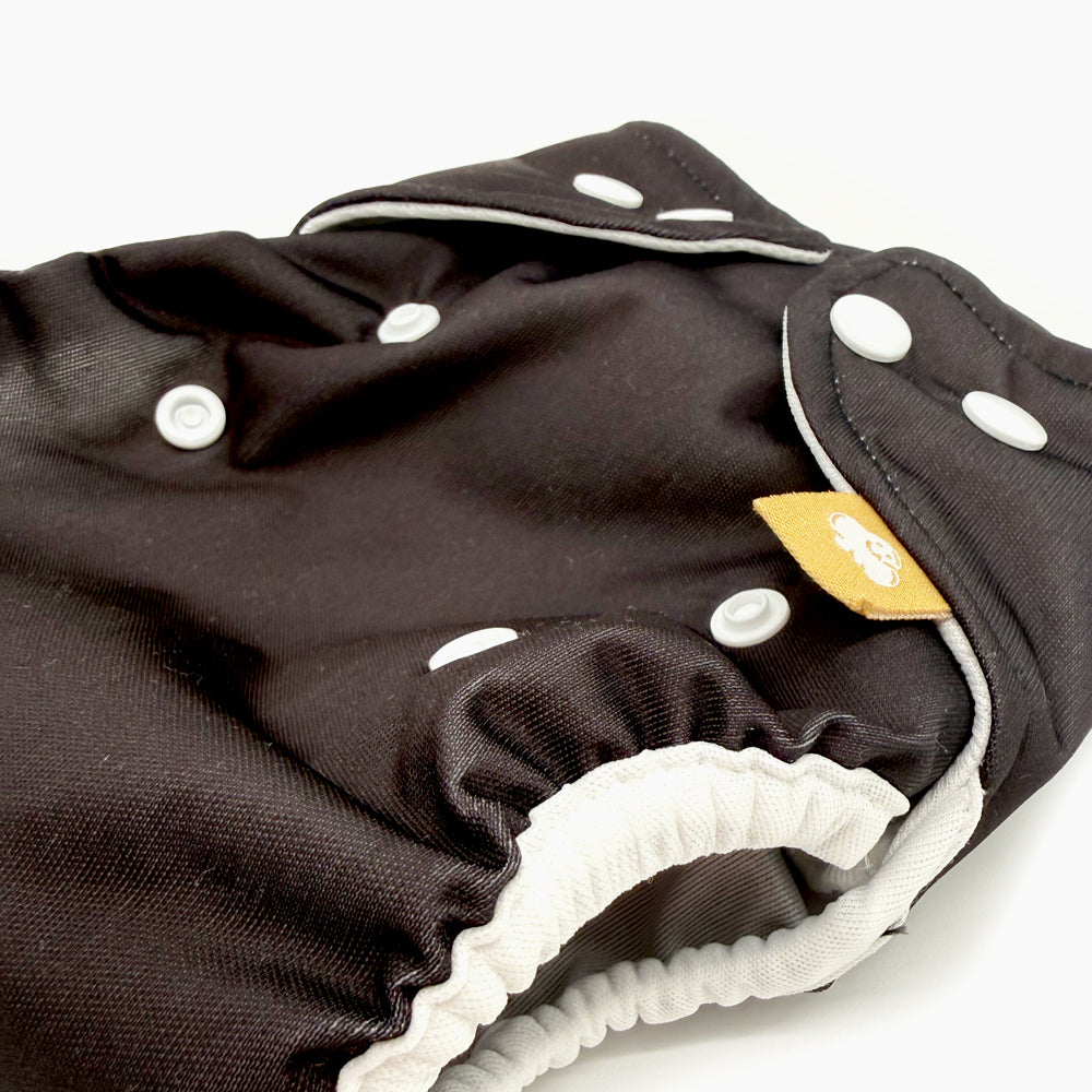 Nahaufnahme der Little Clouds Prefold-Überhose Gold Edition in Schwarz: weiches Beinbündchen und Druckknöpfe