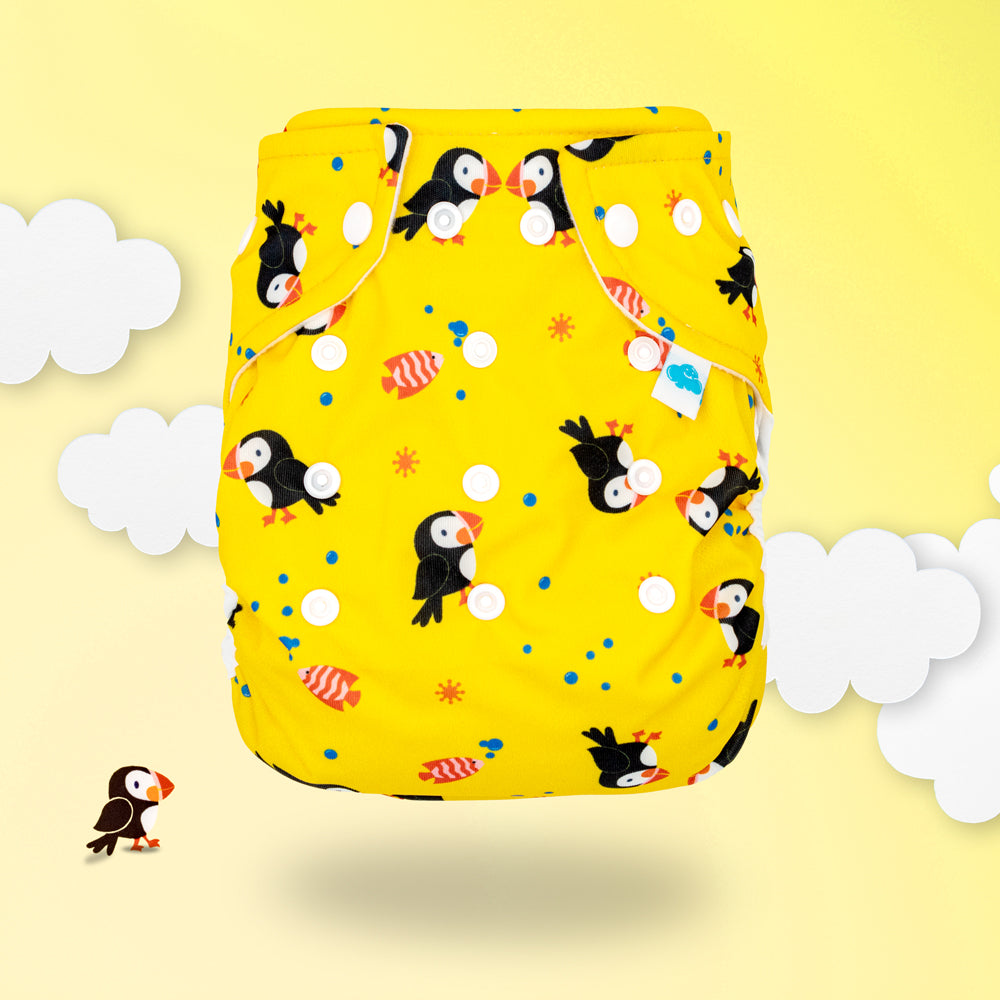 Little Clouds Prefold-Überhose aus PUL im Design Papageientaucher auf gelbem Hintergrund mit Wolken