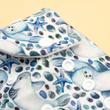 Detailaufnahme der Druckknopfleiste an der Little Clouds Prefold-Überhose aus PUL im Design Robben