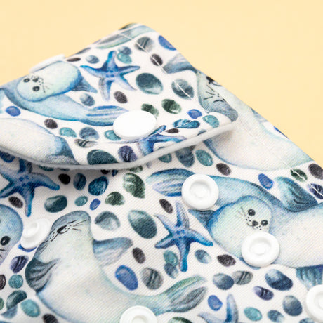 Detailaufnahme der Druckknopfleiste an der Little Clouds Prefold-Überhose aus PUL im Design Robben