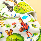 Nahaufnahme der Little Clouds Prefold-Überhose aus PUL im Design Rotkäppchen mit Druckknöpfen und Märchenfiguren wie Eichhörnchen und Wolf