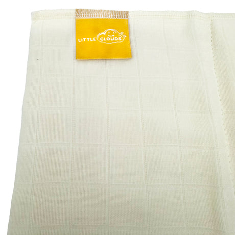Nahaufnahme des Bio-Baumwollstoffs einer Little Clouds Prefold-Windel mit goldenem Etikett