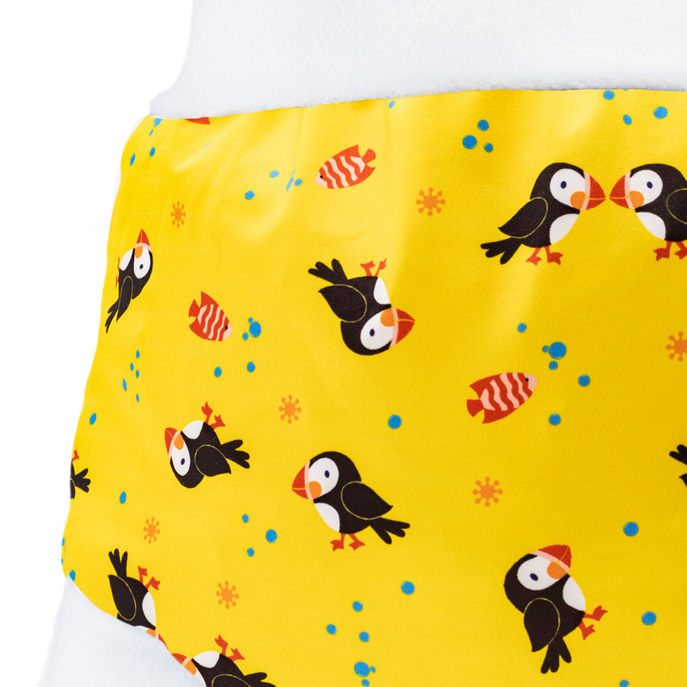Nahaufnahme der Little Clouds Schlupfhose V2 aus PUL im Design Papageientaucher: Papageientaucher auf gelbem Grund