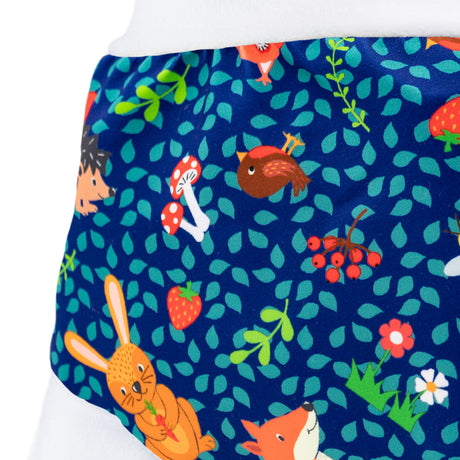 Nahaufnahme der Little Clouds Schlupfhose V2 aus PUL im Design Waldtiere: Füchse, Beeren und Blätter auf dunkelblauem Grund