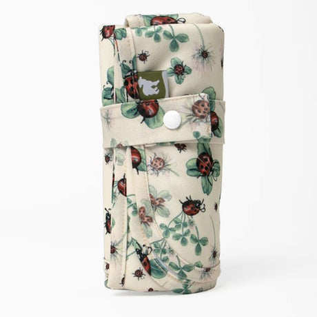 Little Lamb Magic Foldaway Wickelunterlage im Design Ladybug Lullaby mit Marienkäfern auf Creme, aufgerollt mit Druckknopf