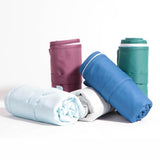 Little Lamb Magic Foldaway Wickelunterlagen in mehreren Unifarben, aufgerollt und nebeneinander gestellt