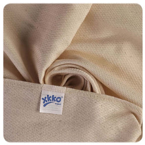 Nahaufnahme der XKKO Birdseye-Mullwindel 50 x 50 cm in Natur mit Logo-Etikett